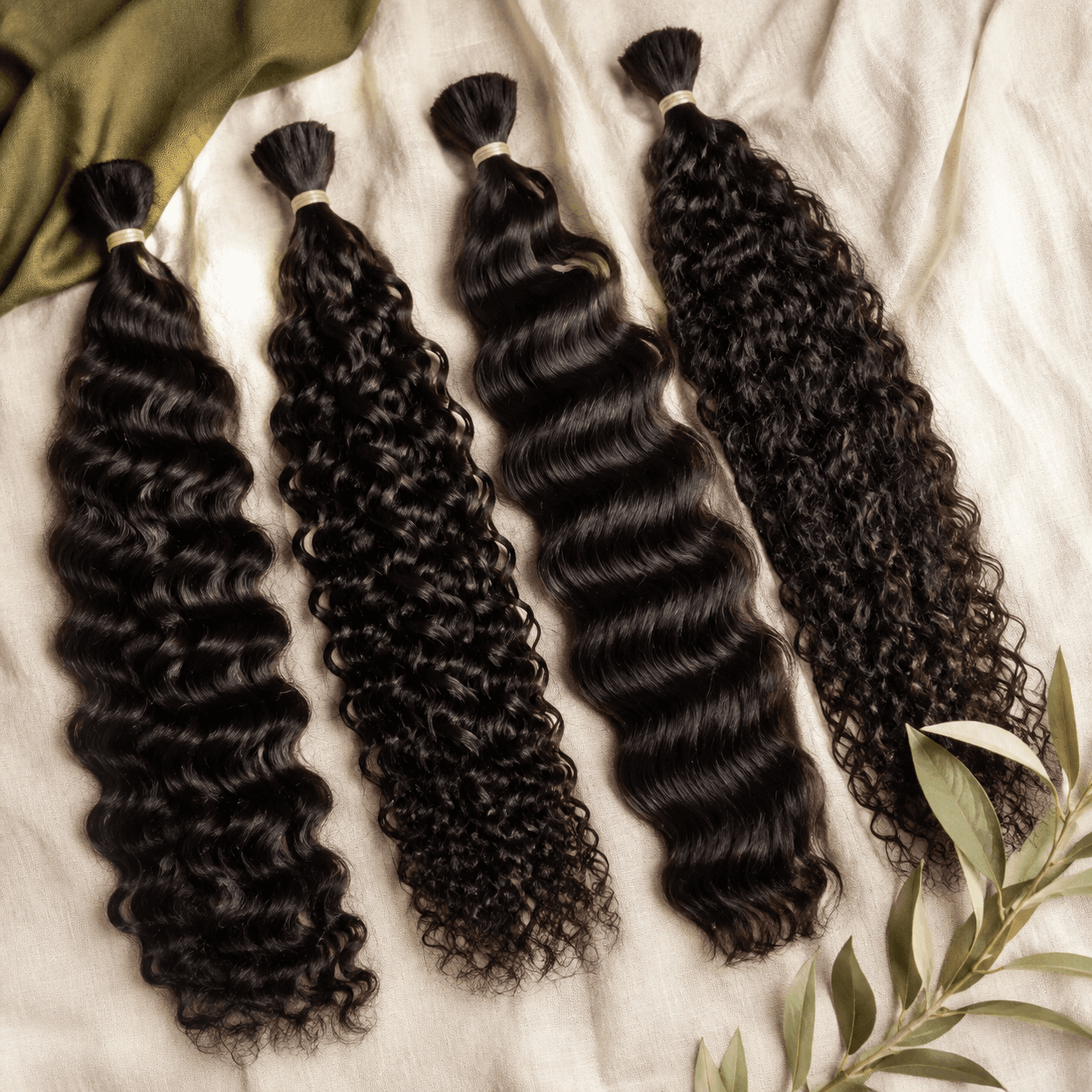 Four loose unwefted natural-black human hair bundles in wave and curl textures for braiding