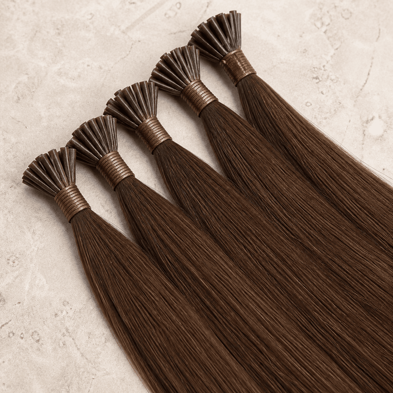 Medium-brown K-tip human hair extension strands with visible keratin bonds